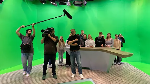 Schülerinnen und Schüler stehen im Greenscreen-Studio des Schleswig-Holstein Magazins.