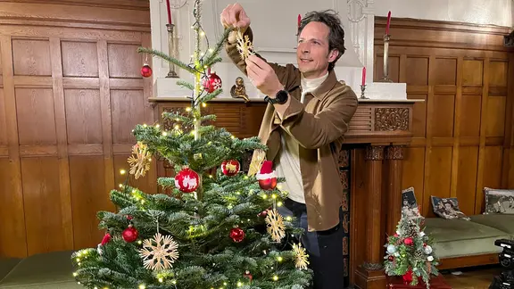 Jo Hiller schmückt einen Tannenbaum. | NDR/Saskia Engels Jo Hiller schmückt einen Tannenbaum.