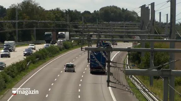 Lkws fahren unter Strommasten auf dem E-Highway zwischen Reinfeld und Lübeck.