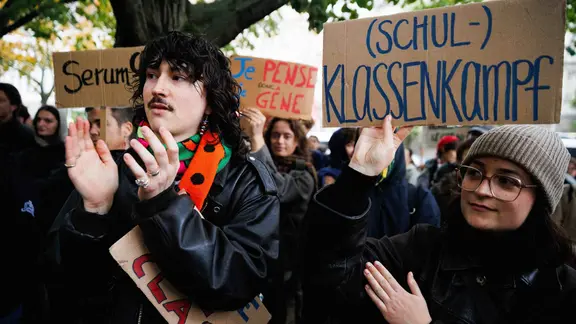Mehrere Demonstrierende halten Schilder.