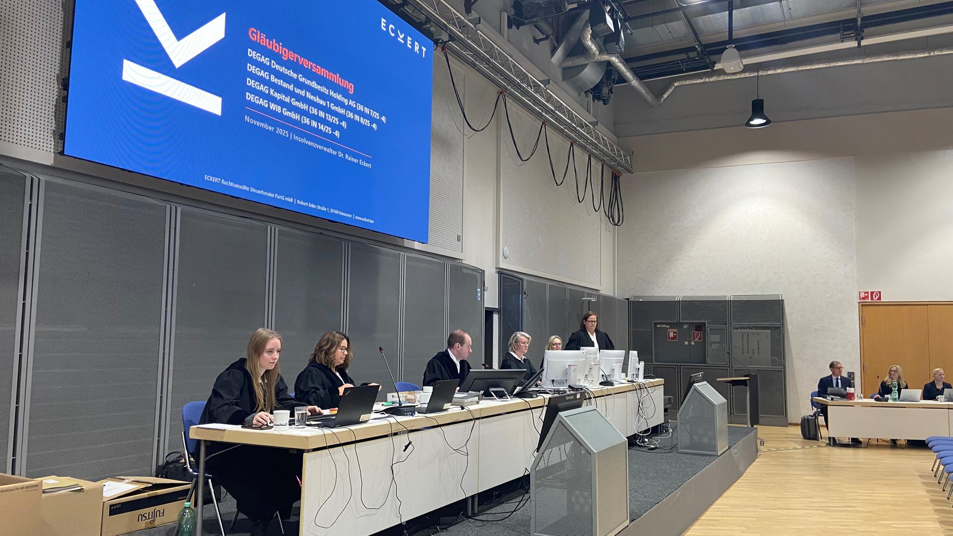 Die Gläubiger sitzen an einem langen Tisch bei der Versammlung. | Wolfgang Kurtz