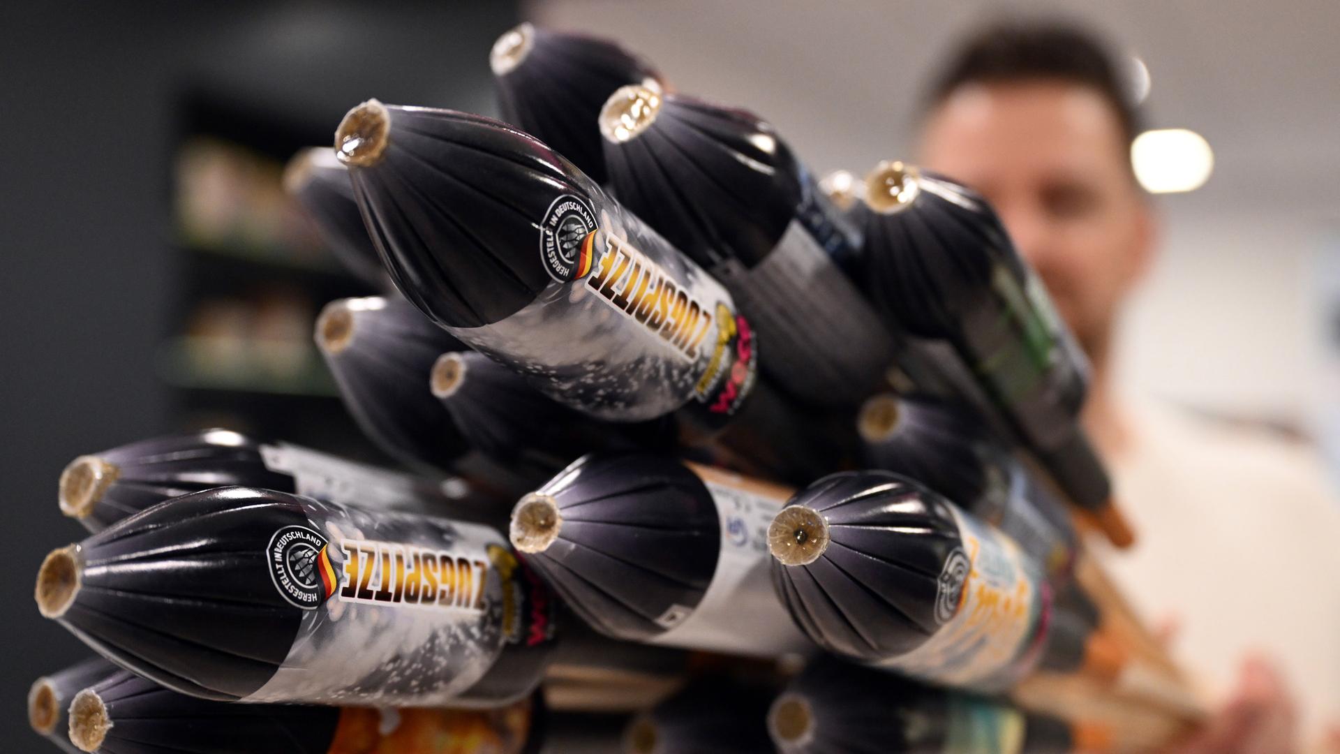 Ein Mitarbeiter hält im Showroom der Feuerwerksfirma Weco Silvesterraketen. | picture alliance/dpa | Federico Gambarini