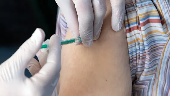 EIne Person wird in den Arm gespritzt.