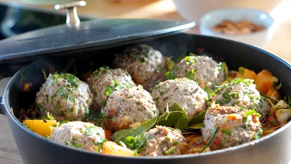 Gemüseeintopf mit Hackbällchen in einem Schmortopf.