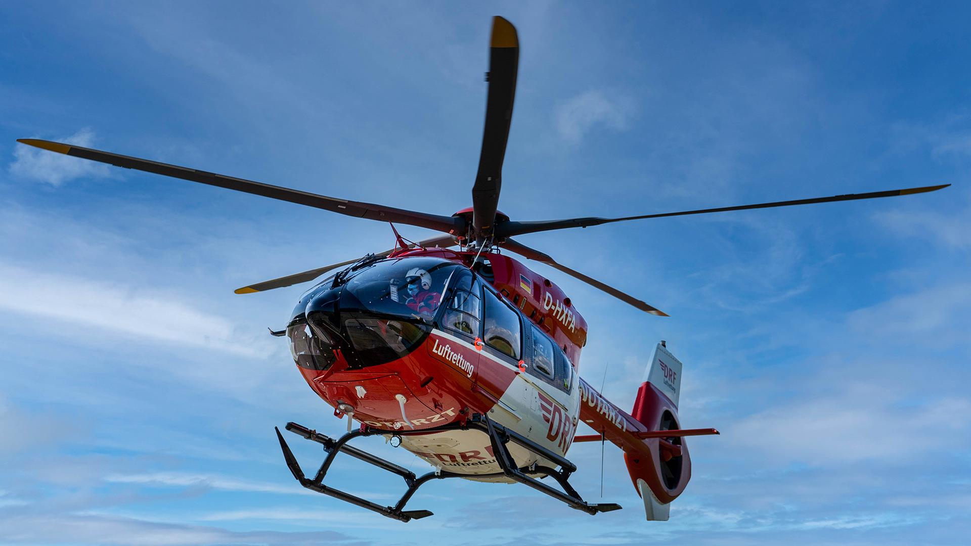 Ein Rettungshubschrauber der DRF Luftrettung schwebt in der Luft. | DRF Luftrettung