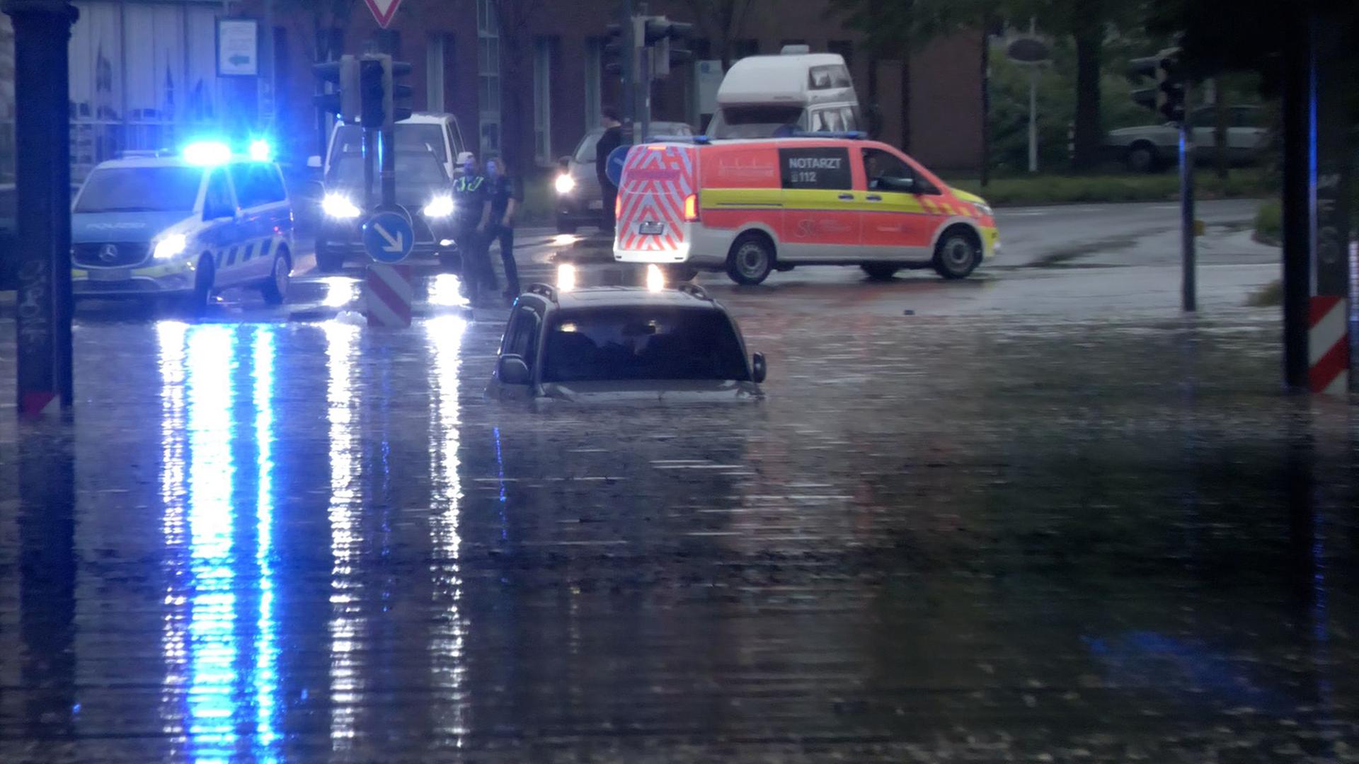 Ein Auto steht in einer überfluteten Straße in einer Unterführung in Rheine. | Bernd März/extremwetter.tv/dpa