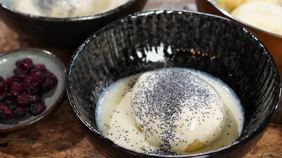 Dampnudeln mit Soße und Mohn in einer Schüssel serviert