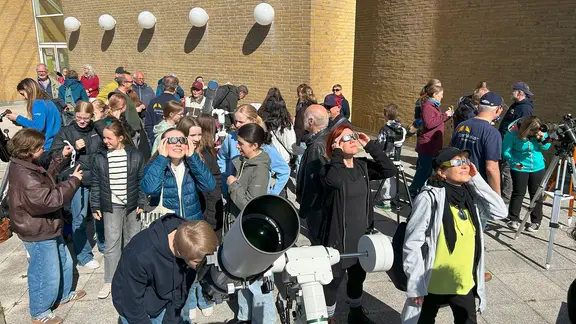 Menschen beobachten am Himmel eine Sonnenfinsterns.