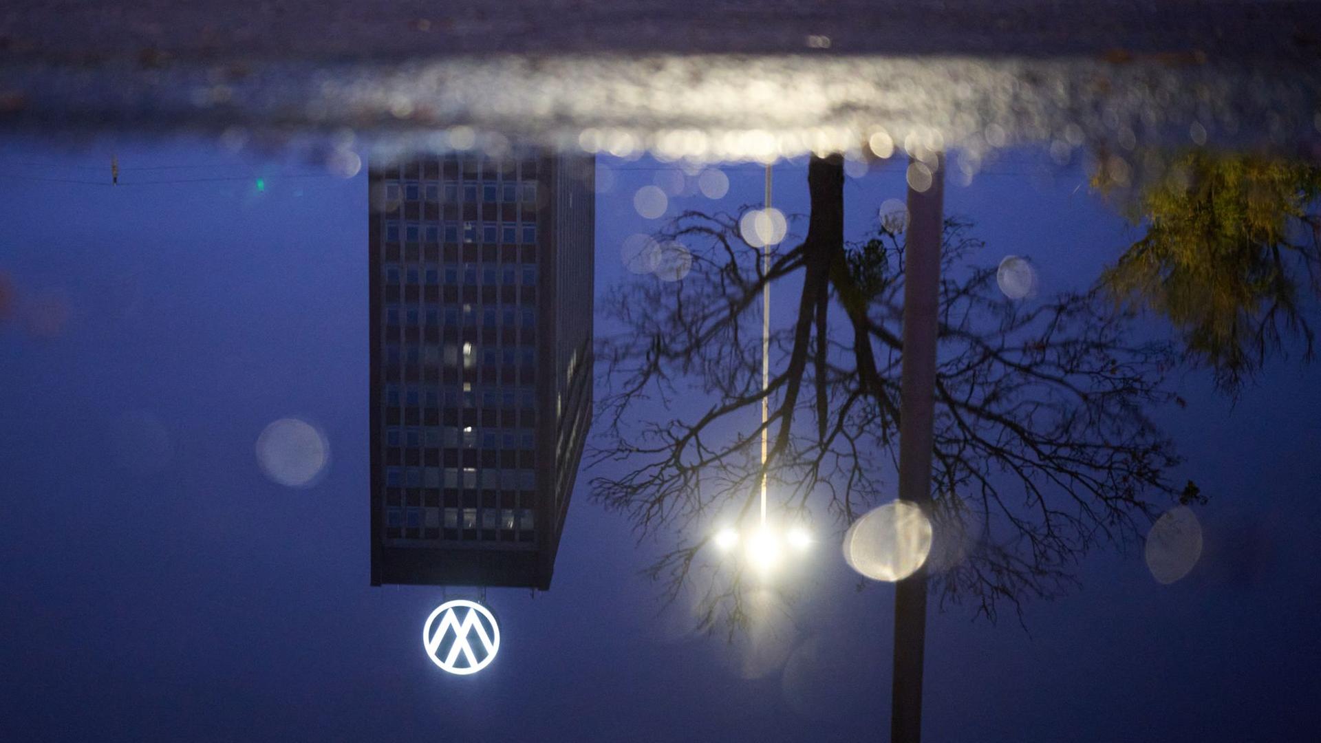 Wolfsburg: Das Markenhochhaus am Volkswagen Stammwerk spiegelt sich in einer Pfütze.  | dpa-Bildfunk, Julian Stratenschulte