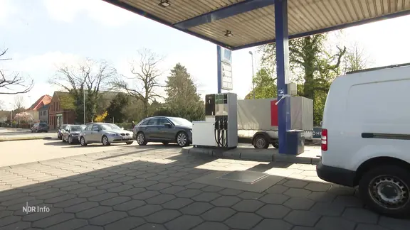 Pkw stehen an einer Tankstelle.
