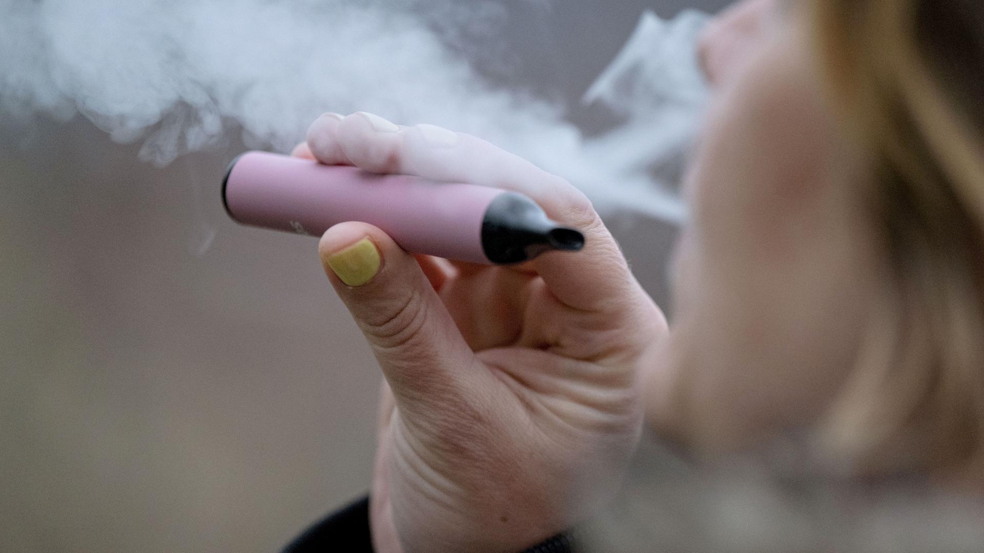 Eine Frau raucht eine elektronische Zigarette (Vape). | picture alliance/dpa | Marijan Murat