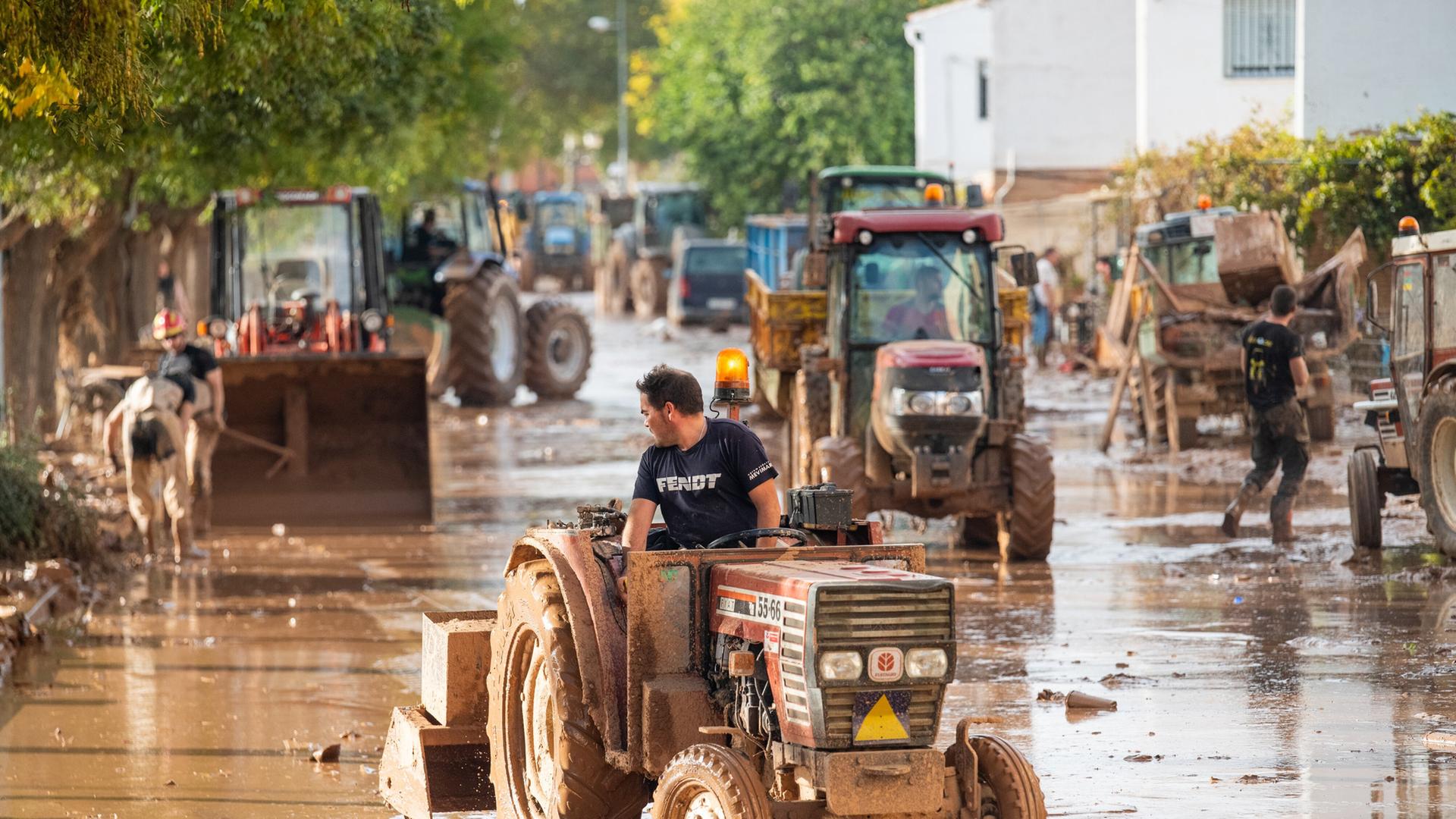 Menschen helfen mit Traktoren bei den Aufräumarbeiten nach dem verheerenden Unwetter, bei dem mehr als 100 Menschen starben.  | picture alliance/dpa/EUROPA PRESS | Víctor Fernández