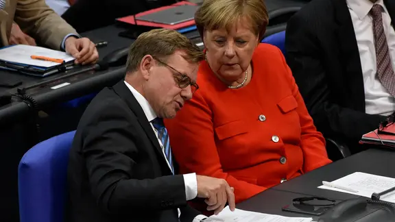 Angela Merkel (r, CDU) und Johann Wadephul (CDU) unterhalten sich im Bundestag.