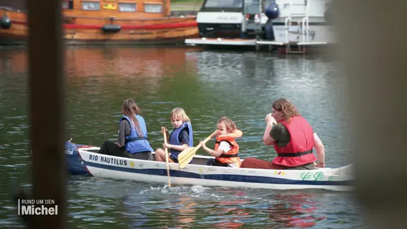 Eine Familie paddelt in einem Kanu auf dem Osterbrook-Kanal.