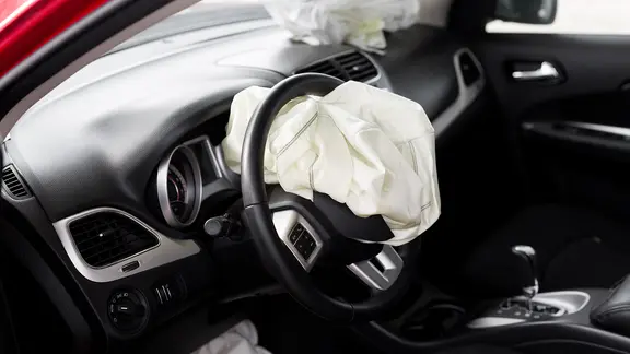 Der Innenraum eines Autos mit geplatzten Airbags. 