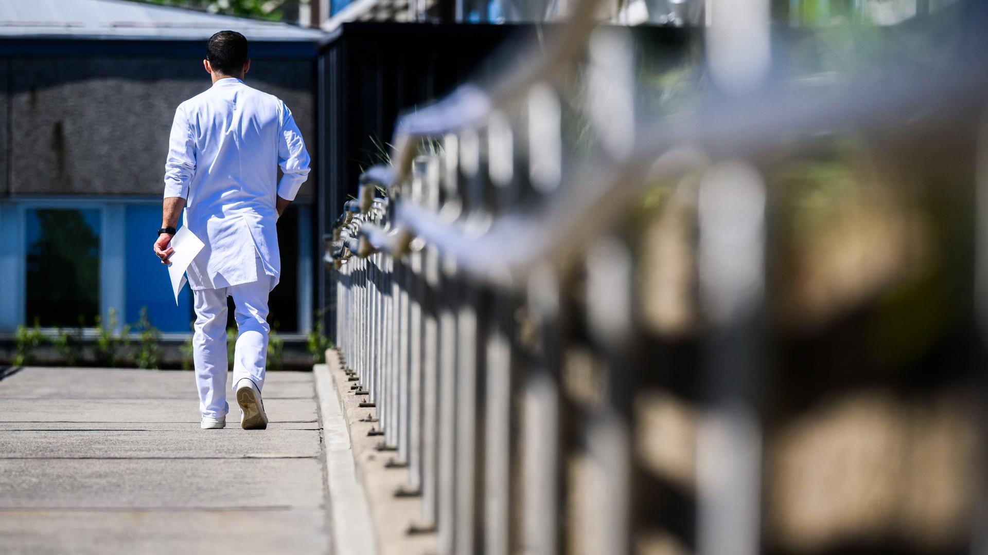 Ein Arzt läuft über das Gelände der Medizinischen Hochschule Hannover MHH.  | dpa, Julian Stratenschulte