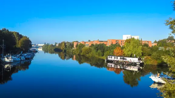 Blick auf die Bille in Hamburg mit Sportbooten und Hausboot.