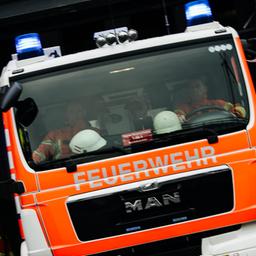 Ein Feuerwehrauto im Einsatz. Nachbarn hören einen Rauchmelder, rufen den Notruf.