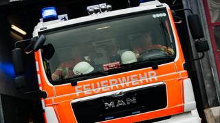 Ein Feuerwehrauto im Einsatz. Nachbarn hören einen Rauchmelder, rufen den Notruf.