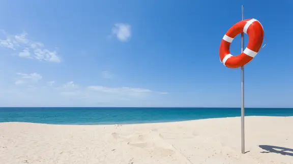 Ein Rettungsring hängt am Strand.