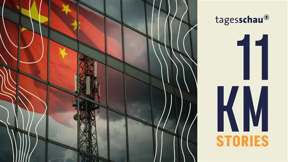 Ein 5G-Mast vor einem Gebäude in dessen Fenster sich eine chinesische Flagge spiegelt.