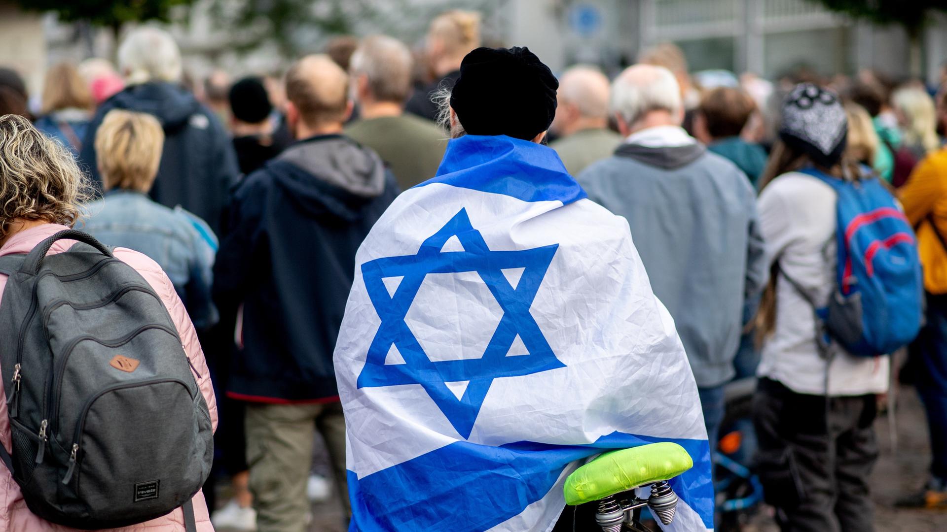 Ein Teilnehmerin einer Kundgebung zur Solidarität mit Israel steht auf dem Julius-Mosen-Platz in Oldenburg. (Archiv)  | picture alliance / dpa, Hauke-Christian Dittrich