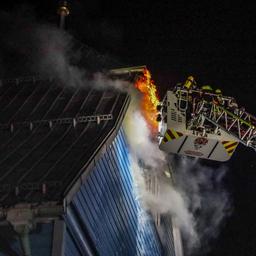 Feuerwehrleute bekämpfen über eine Drehleiter den Brand einer Holzkirche in Clausthal-Zellerfeld.