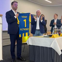 Christopher Vogt (FDP) hält ein Trikot mit seinem Namen in den Händen.