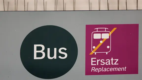 Eine Hinweisschild für den Bus- und Schienenersatzverkehr hängt an einem Bahnhof.