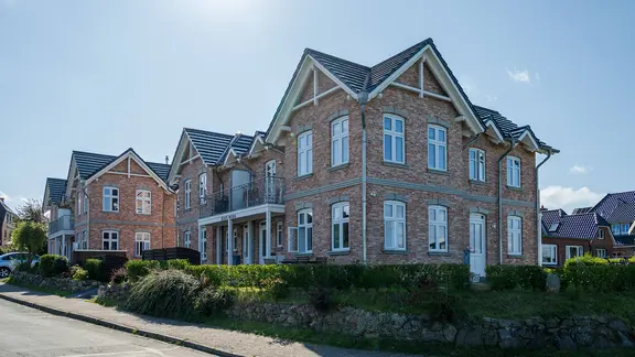 Eine Straße mit Gebäuden für Ferienwohnungen in Norddorf auf Amrum.