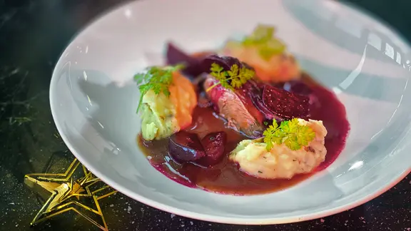 Rehschulter mit roter Bete und und Thymian-Kartoffelstampf auf einem weißen Teller angerichtet