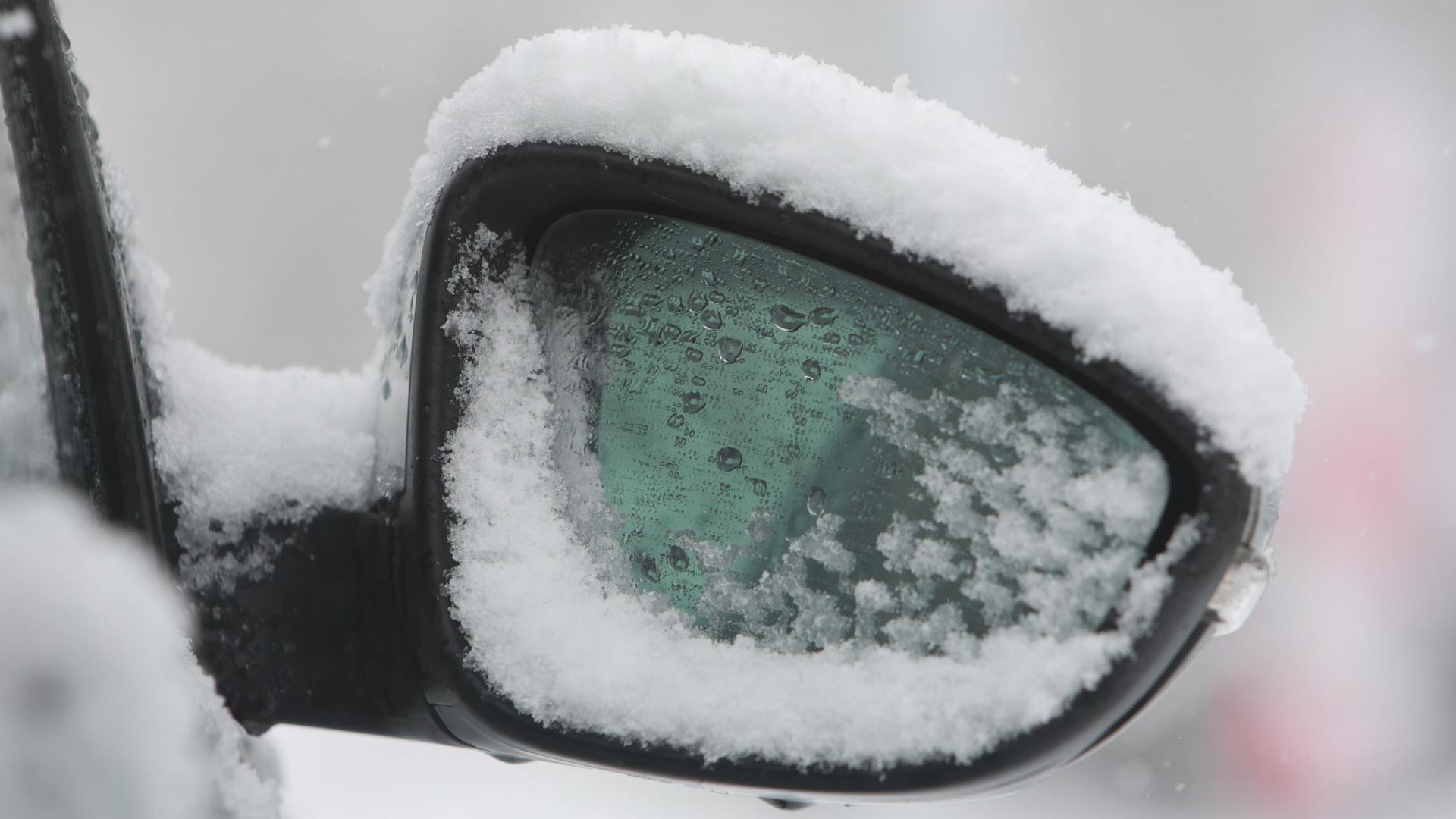 Der Seitenspiegel eines Fahrzeugs ist schneebedeckt.  | picture alliance/dpa, Matthias Bein