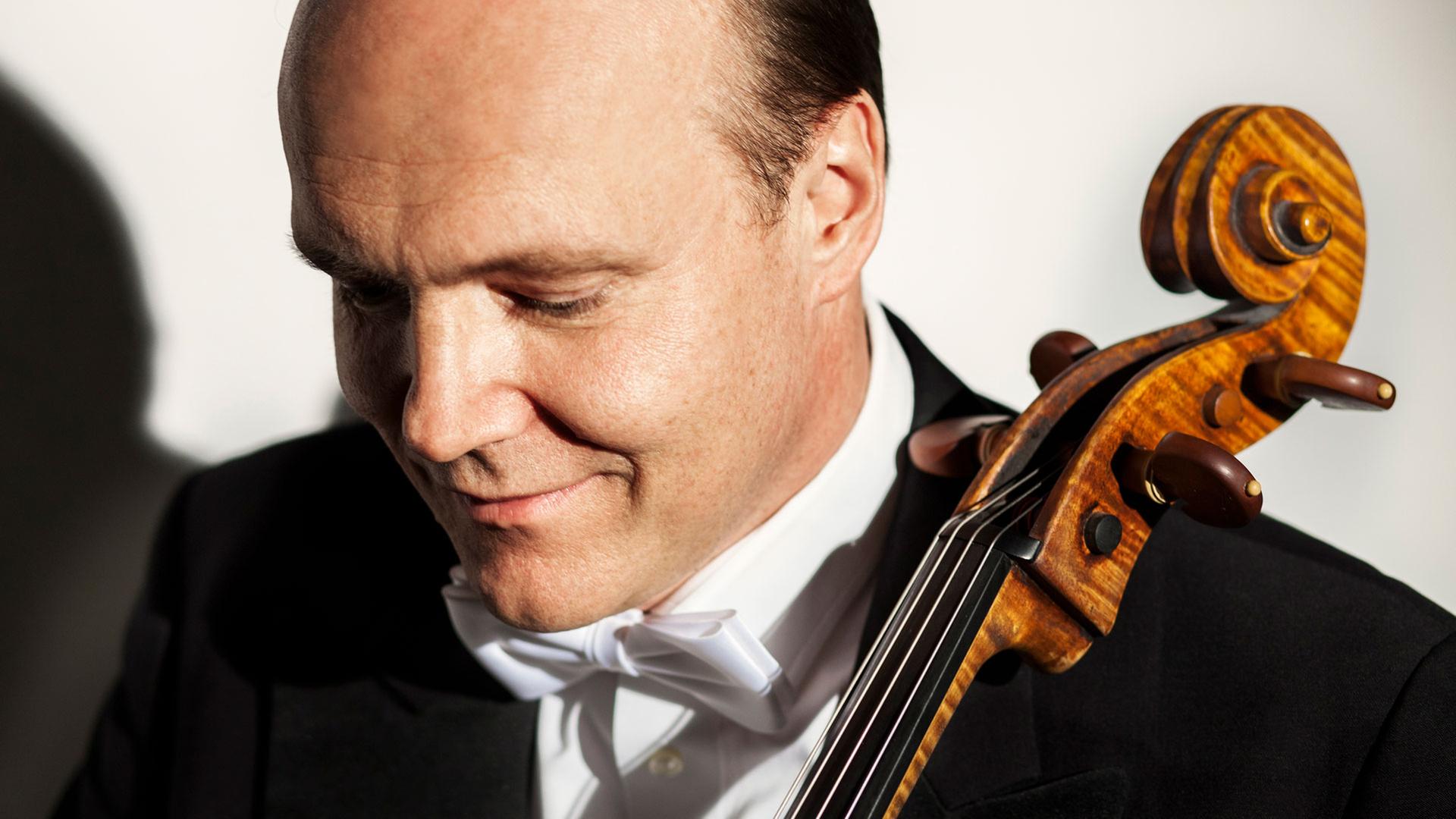 Ein Mann mit weißer Fliege hält ein Cello fest. | NDR, Johs Boe