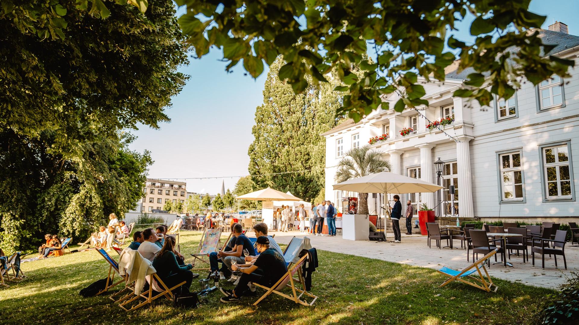 Menschen sitzen in einem Garten der Landesgartenschau. | Landesgartenschau Bad Nenndorf, Marie-Christin Pratsch