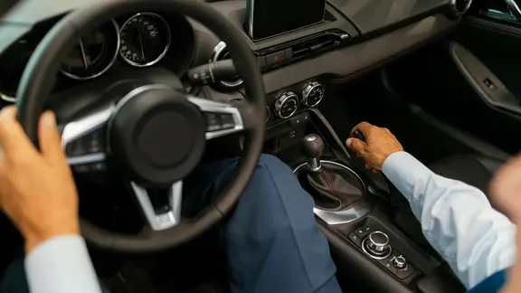 Ein Mann hält ein Autolenkrad in der Hand.