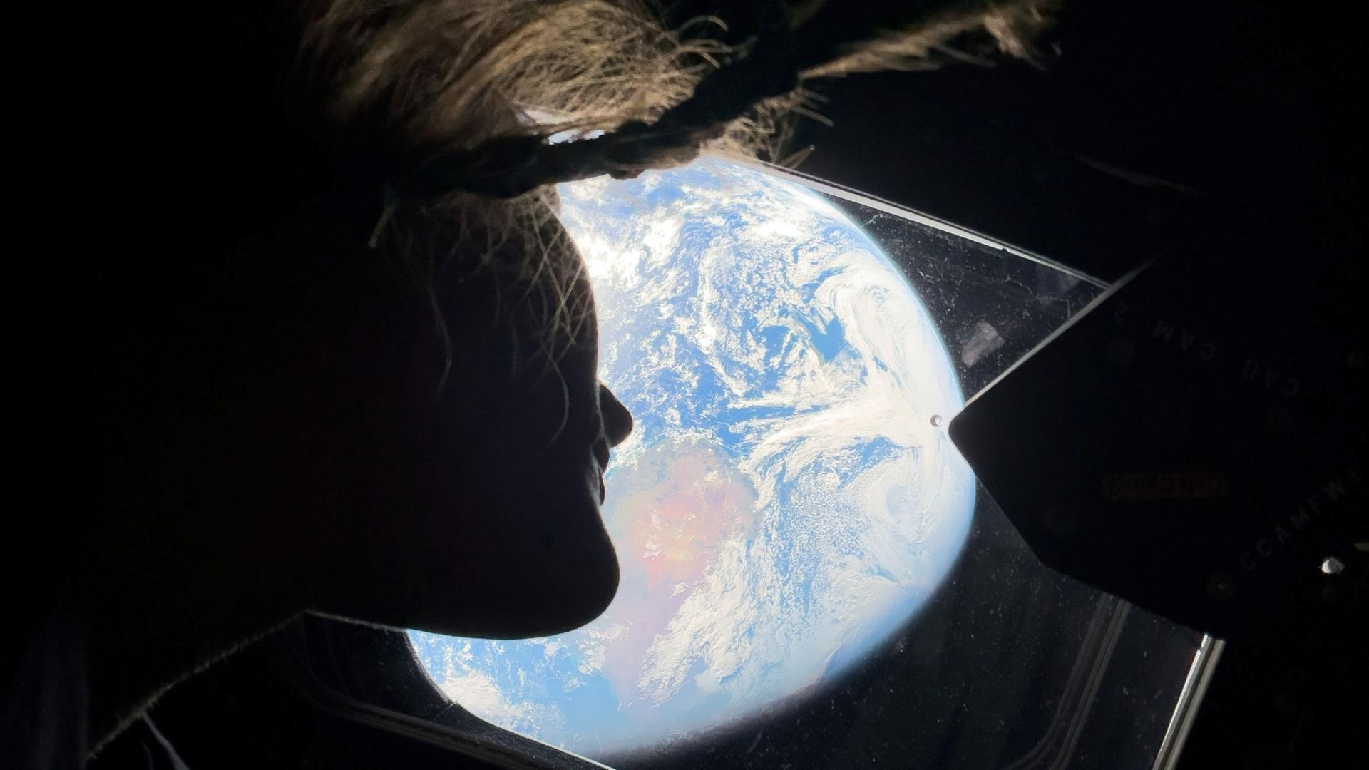 Die Artemis-Astronautin Christina Koch schaut aus dem Raumschiff auf die Erde | picture alliance / ZUMAPRESS.com | Nasa/Nasa