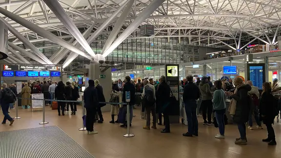 Reisende stehen nach dem Ende der Geiselnahme am Hamburger Flughafen.