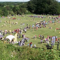 Blick auf eine Gruppe von Menschen, die sich auf dem Knivsberg zu einem Treffen mit Sport und Ständen versammelt hat.