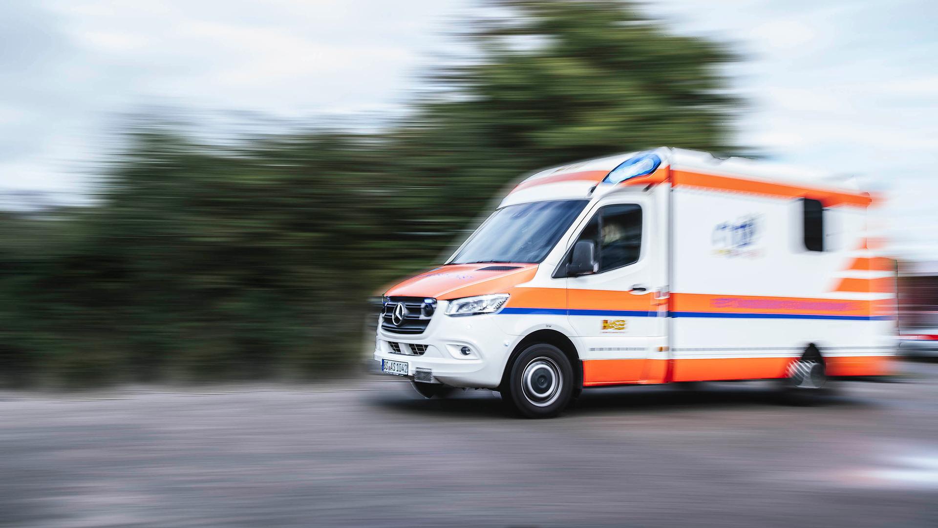 Ein Rettungswagen in Unschärfe fährt mit eingeschaltetem Blaulicht auf einer Straße. | NDR, Julius Matuschik
