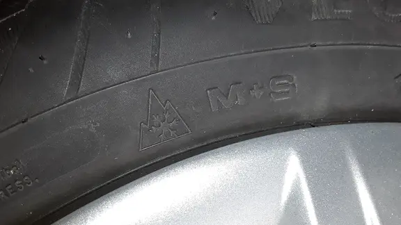 Reifen für den Winter müssen ein Symbol mit Bergpiktogramm und Schneeflocke tragen. | NDR, Axel Franz Winterreifen-Symbol auf einem Autoreifen