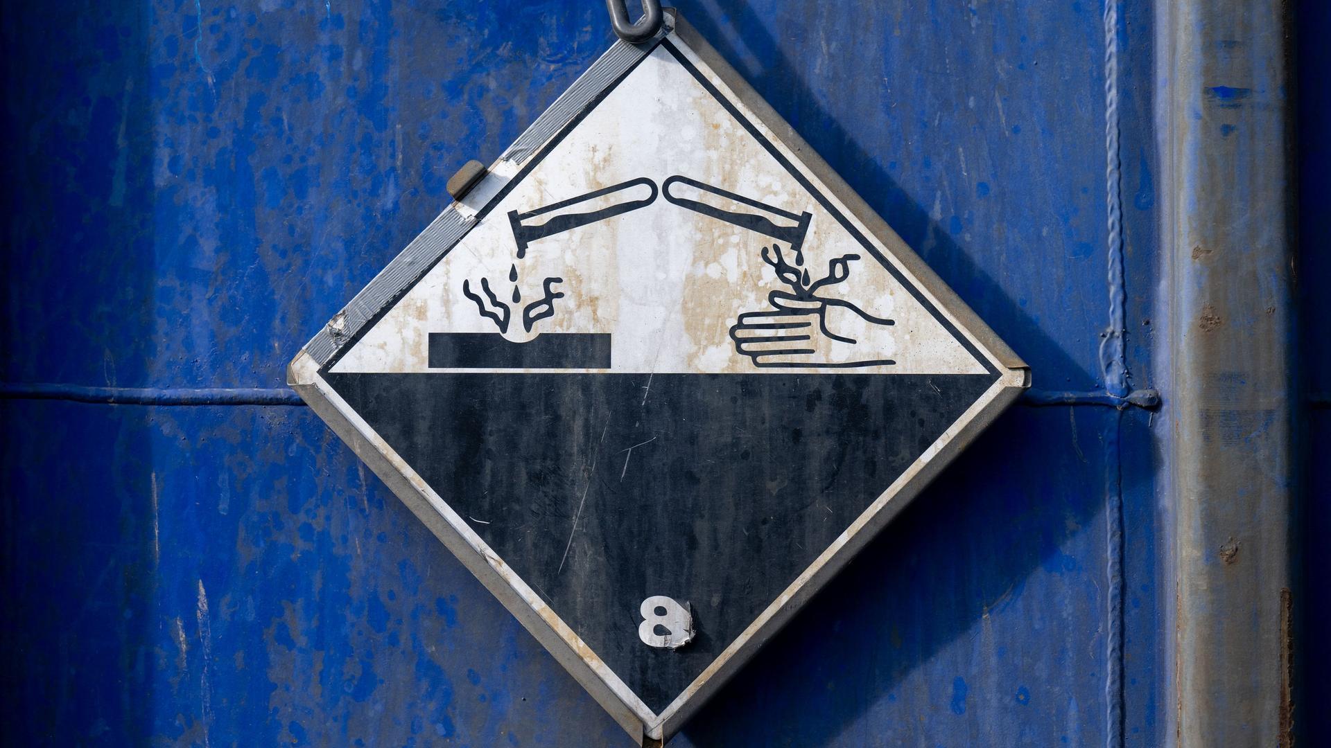 Ein Gefahrgutzeichen für ätzende Stoffe ist auf einem LKW zu sehen. | dpa, Hendrik Schmidt