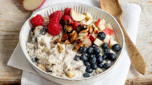 Eine Schale mit einem Müsli, garniert mit Beeren und Nüssen, daneben ein Löffel. | ZS-Verlag, Claudia Timmann Eine Schale mit einem Müsli, garniert mit Beeren und Nüssen, daneben ein Löffel.