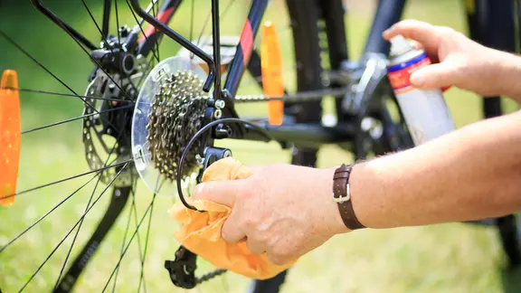Die neue Saison ist ein guter Zeitpunkt, um das Rad einmal gründlich zu reinigen. | Colourbox, Simon Kadula Nahaufnahme einer Person bei einer Fahrrad-Reinigung.