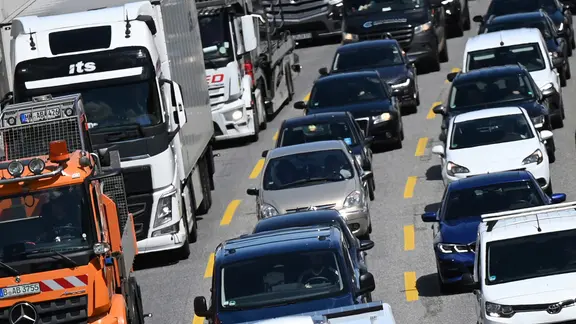 Autos und Lastwagen stehen auf einer Autobahn in Hamburg im Stau.