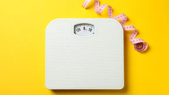 Eine Personenwaage und und Maßband auf gelbem Hintergrund. | Colourbox, AtlasStudio Eine Personenwaage und und Maßband auf gelbem Hintergrund.