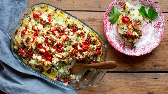 Feta eignet sich gut zum Überbacken deftiger Aufläufe mit Hackfleisch und Kohl. | NDR, Claudia Timmann Spitzkohlauflauf in einer Auflaufform und ein gefüllter Teller mit Auflauf stehen auf dem Tisch.