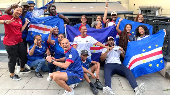 Fans der Nationalmannschaft von Kap Verde mit Trikots und Fahnen auf einem Gruppenbild.