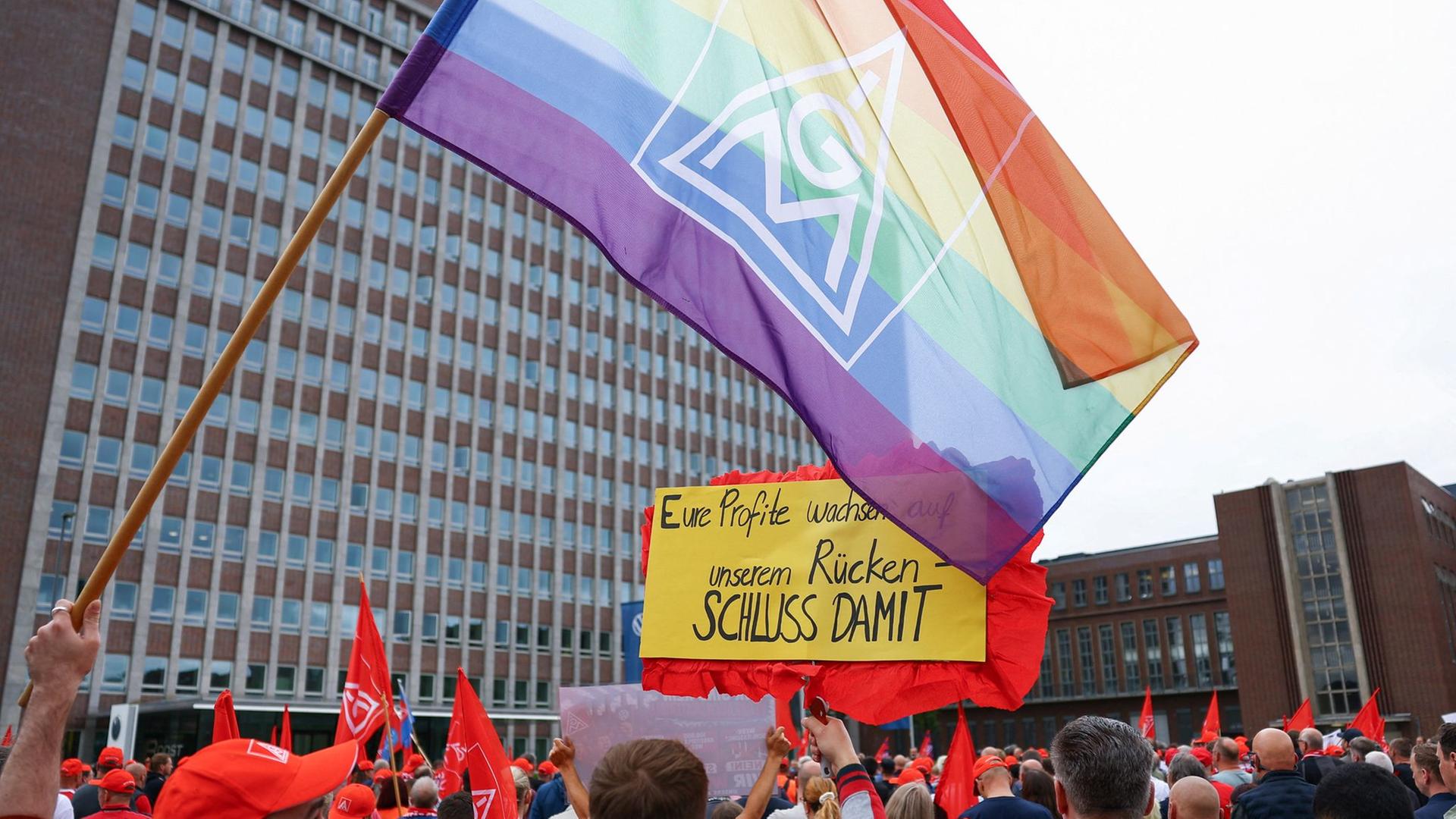 Ein Mann hält in Wolfsburg eine Regenbogenfahne mit dem IG Metall-Logo hoch | dpa/Lisi Niesner