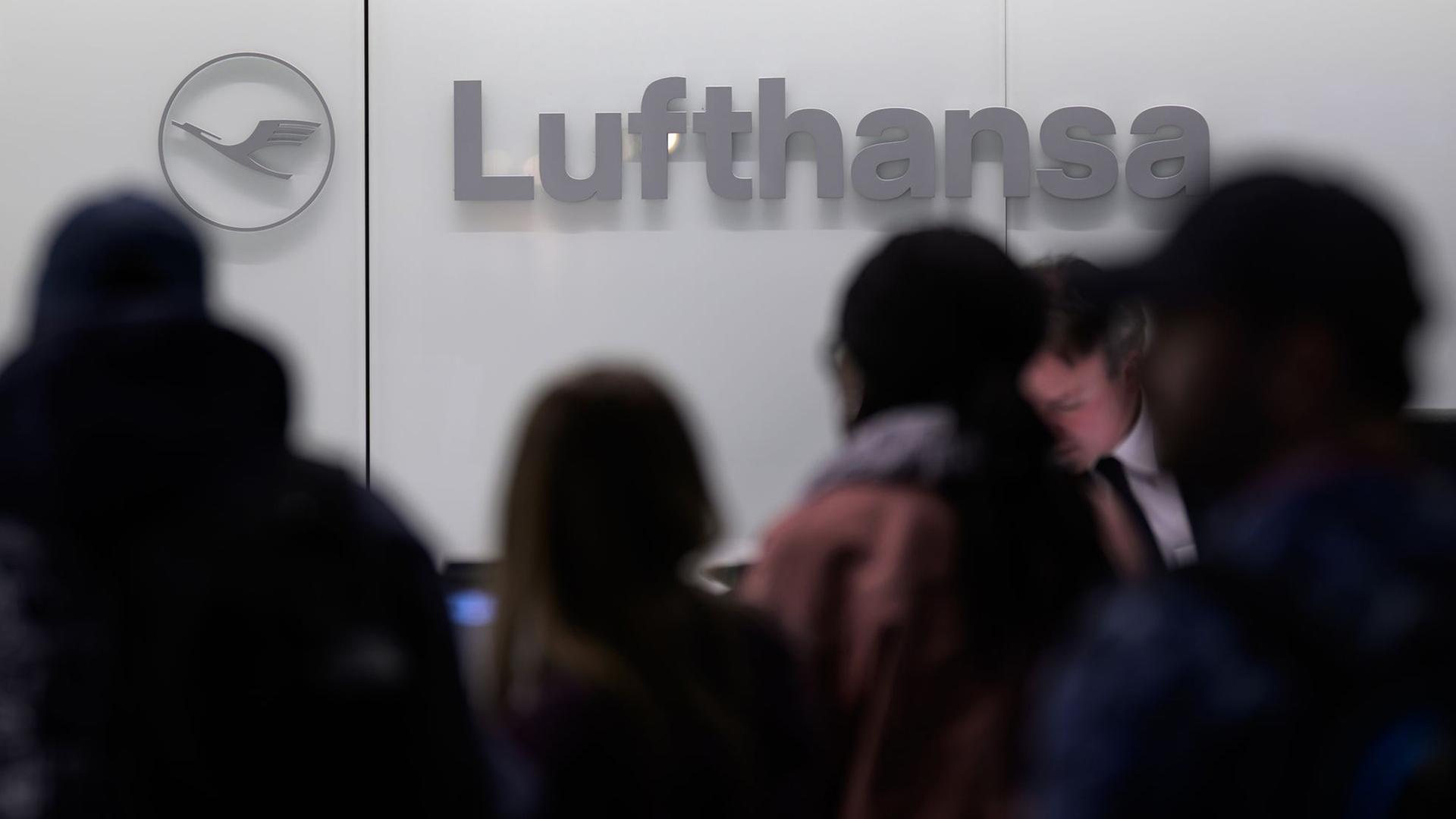 Menschen stehen vor einem Lufthansa-Schalter am Flughafen. | dpa, Hannes P. Albert