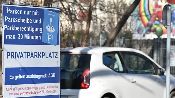 Auf einem Schild neben einem Supermarkt-Parkplatz ist zu lesen: "Parken nur mit Parkscheibe und Parkberechtigung max. 30 Minuten. Es gelten aushängende AGB. Ohne gültige Parkberechtigung und Parkscheibe wird eine Vertragsstrafe von 30 Euro erhoben."
